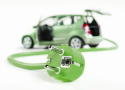 Elektroauto mit Stromstecker Grünes Auto im Hintergrund mit Stecldose zum Laden