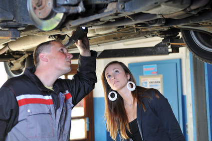 Förderung für Rußpartikelfilter beantragen Mechaniker und junge Frau begutachten Auto von unten
