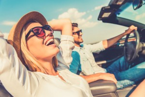 Neue Typklassen- und Regionalklasseneinteilung ab 2017 Junges Paar genießt die Fahrt in einem offenen Cabrio bei Sonnenschein